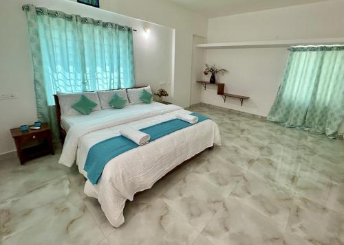 Un dormitorio con una cama grande con cortinas azules. en Tirupati Homestay - Shilparamam - Luxury AC apartments by Stayflexi - Fast WiFi, Kitchen, Android TV - Walk to PS4 Pure Veg Restaurant - Easy access to Airport, Railway Station and to all Temples, en Tirupati