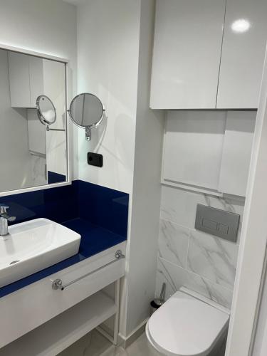 a bathroom with a sink and a toilet and a mirror at The best beach aparthotel Orbi city Batumi in Batumi