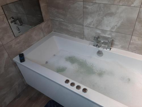 a bath tub filled with water in a bathroom at Fountain Cottage Cafe and B&B in Bellingham