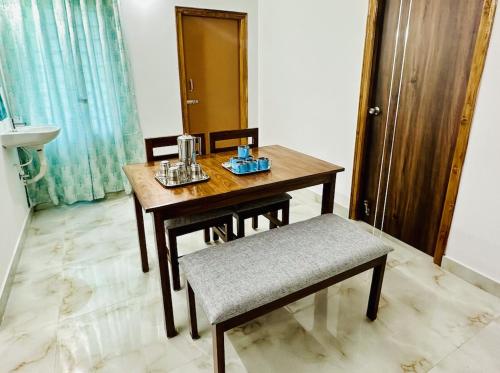 una mesa de madera y una silla en una habitación en Tirupati Homestay - Shilparamam - Luxury AC apartments by Stayflexi - Fast WiFi, Kitchen, Android TV - Walk to PS4 Pure Veg Restaurant - Easy access to Airport, Railway Station and to all Temples, en Tirupati