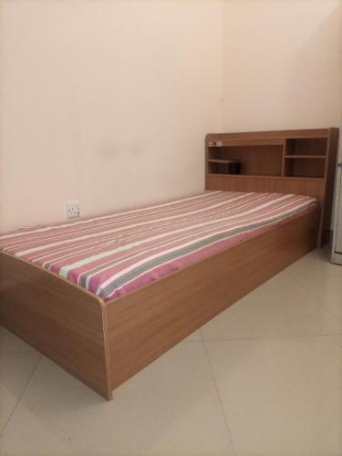 een bed met een houten frame in een kamer bij Mixed dormitory, only for Indians in Sharjah
