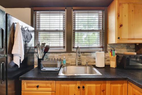 a kitchen with a sink and a black refrigerator at Lake View Enchanted Treehouse- Lake Harmony in Lake Harmony