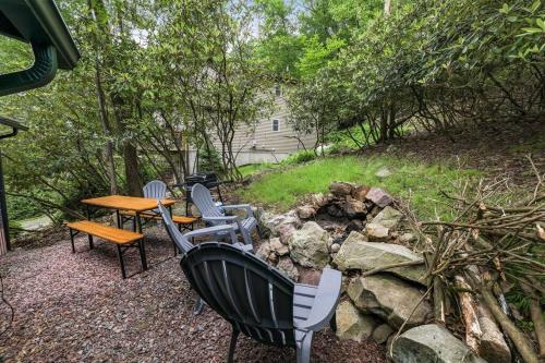 a backyard with a table and chairs and a fire pit at Lake View Enchanted Treehouse- Lake Harmony in Lake Harmony