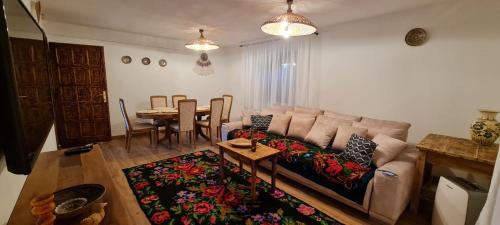 a living room with a couch and a table at Acul în carul cu fan in Pădurenii