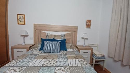 a bedroom with a large bed with blue pillows at Vivienda Uso Turístico Las Gemelas de Arevalo in Arévalo
