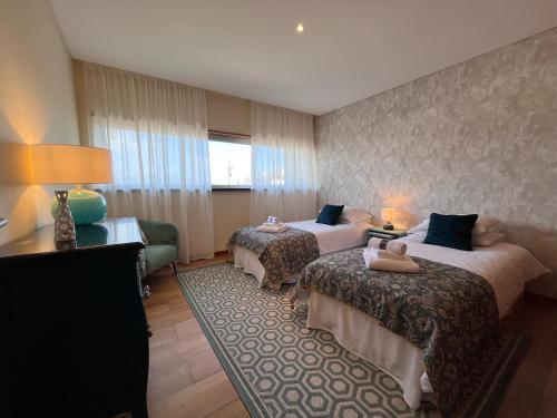 a hotel room with two beds and a couch at Lovely&Charming Anita’s apartment in Ponta Delgada