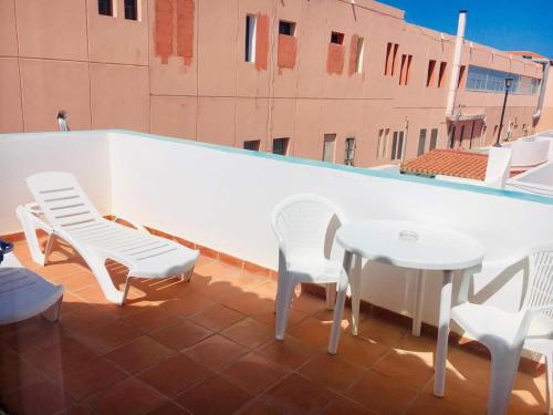 d'une terrasse sur le toit avec des chaises blanches et des tables. dans l'établissement La Casita di Fuerte, à Caleta de Fuste