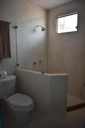 a bathroom with a toilet and a tub and a window at LUNA AZUL BY UVAS in Cozumel