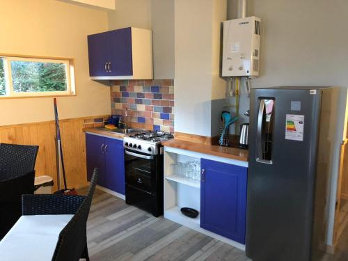 蒙特港的住宿－CABAÑAS ANAHUAC，厨房配有蓝色橱柜和黑色冰箱。