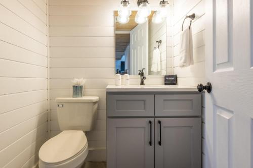 uma casa de banho com um WC, um lavatório e um espelho. em Smoky Sunrise Getaway em Gatlinburg