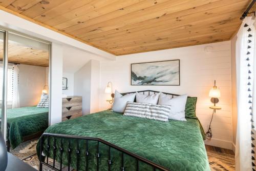 a bedroom with a green bed and a wooden ceiling at Smoky Sunrise Getaway in Gatlinburg