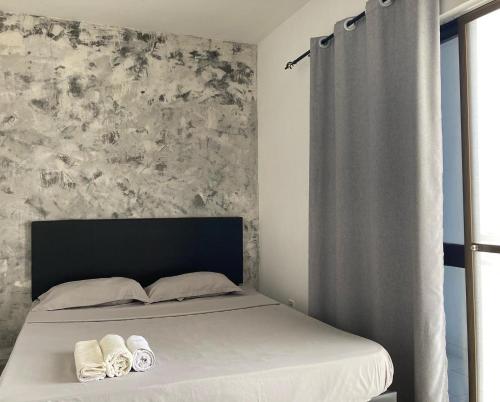 1 dormitorio con 1 cama con 2 toallas en Cantinho C - Alojamento Complementar, en Praia