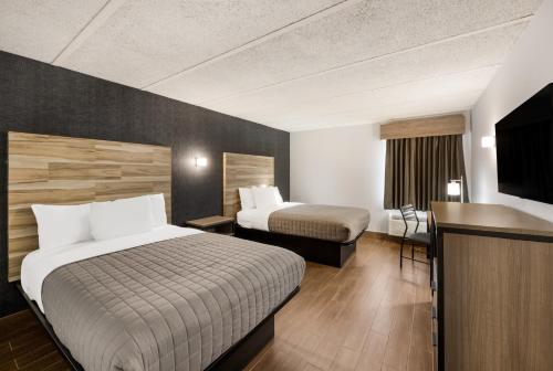 um quarto de hotel com duas camas e uma televisão de ecrã plano em Essence Express Wayne em Wayne