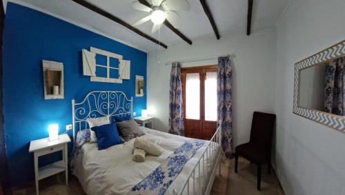 a blue bedroom with a bed with a blue wall at Casa Cuartel in El Gastor