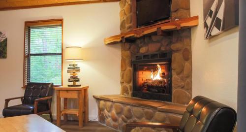 ブロークン・ボウにあるThe Trail House at Eagle Ridge cabinのリビングルーム(石造りの暖炉、テレビ付)
