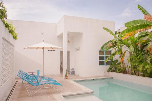 a swimming pool with a blue chair and an umbrella at Casa Celeste Honda in Honda