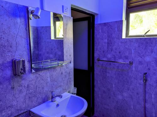 a purple bathroom with a sink and a mirror at Serendip Villa Holiday HomeTalalla Sri Lanka in Matara