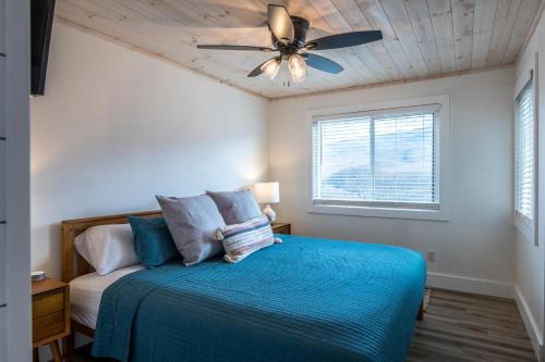 Schlafzimmer mit einem blauen Bett und einem Deckenventilator in der Unterkunft Mountain Twilight in Gatlinburg