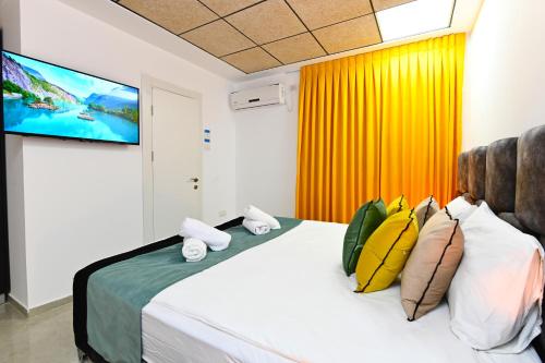a bedroom with a bed with a flat screen tv at Yalarent Malina motel in Tiberias in Tiberias