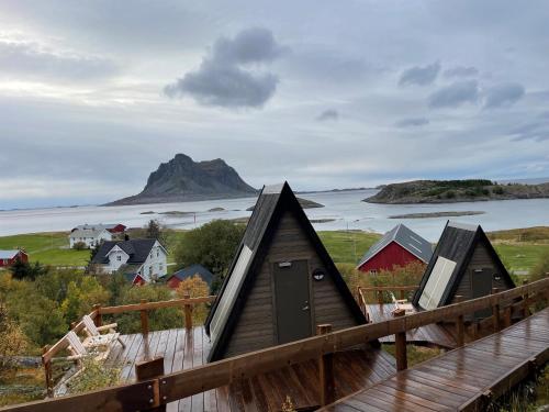 a group of huts on a hill next to the ocean at BaseCamp Vega in Sundsvoll