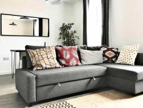 a gray couch with pillows on it in a living room at Sea Street House in Kent