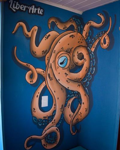 a painting of an octopus on the wall of a room at Mar de Fondo Hostel in Punta Del Diablo
