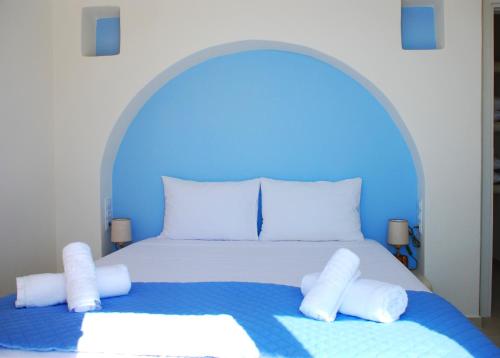 1 dormitorio azul con 1 cama con almohadas blancas en Aelia Mare Penthouse, en Istérnia