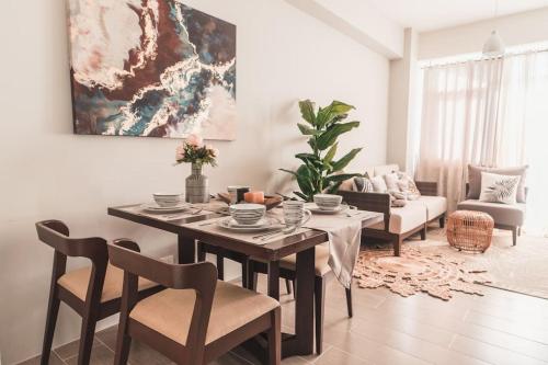 uma sala de estar com uma mesa e cadeiras e um sofá em Modern Tropical Luxe Apartment - Ilig-Iligan Beach em Boracay