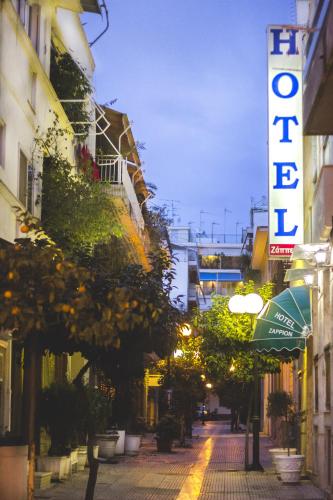 a city street at night with a hotel sign and trees at Zappion Hotel in Athens