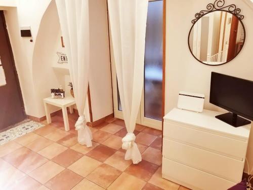 sala de estar con cortinas blancas y TV en Blanco's home, en Nápoles