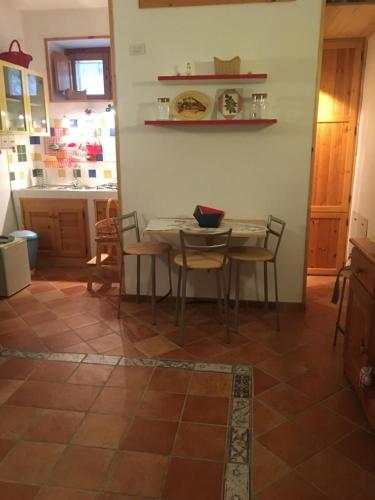a kitchen with a table and chairs in a room at La casa di Tiziana in Villalago