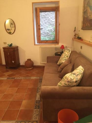 a living room with a brown couch and a window at La casa di Tiziana in Villalago
