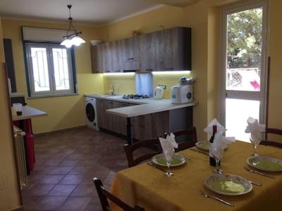 una cucina con tavolo e sedie e una cucina con tavolo e sedie. di Villa Bella Vista a Palermo