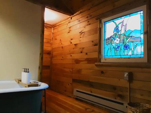 a bathroom with a sink and a stained glass window at Adirondack Cottage Retreat in Elizabethtown