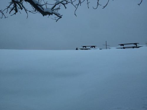 three picnic tables sitting on top of a snow covered field at Hotel Bad Langensalza Eichenhof in Bad Langensalza