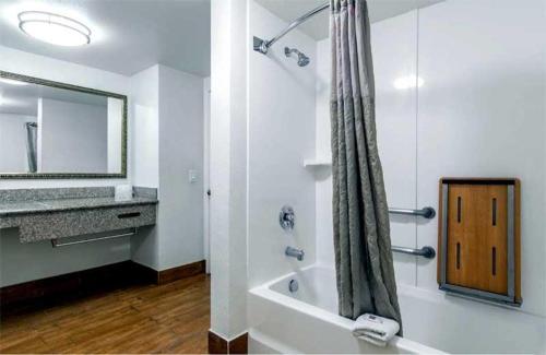 uma casa de banho com uma banheira, um lavatório e um chuveiro em Beachside Inn em Anaheim