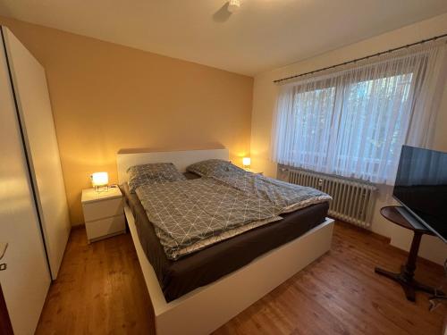Un dormitorio con una cama y un escritorio y una ventana. en Ferienwohnung am See, Überlingen, en Überlingen