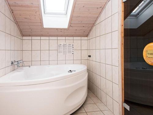 y baño con aseo y bañera. en 10 person holiday home in B rkop en Egeskov