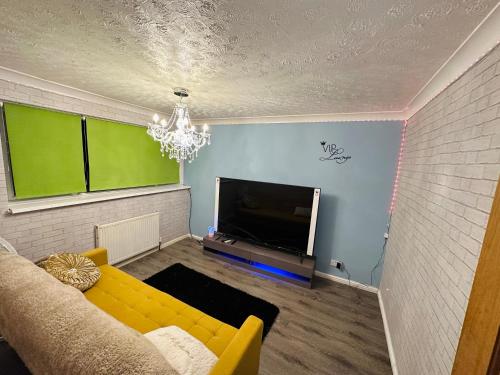 a living room with a yellow couch and a flat screen tv at Double Room with Private Shower room Close to City center and UOB Free Onsite Parking Private Fridge with Shared Kitchen and Lounge access in Northfield