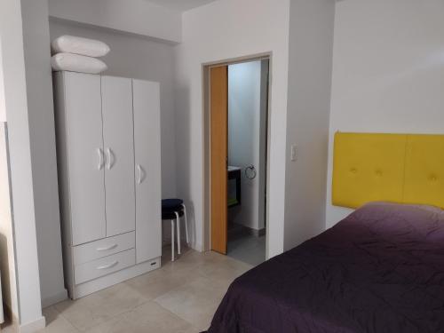 1 dormitorio con cama y espejo de color amarillo en DEPARTAMENTO METRO E en Buenos Aires