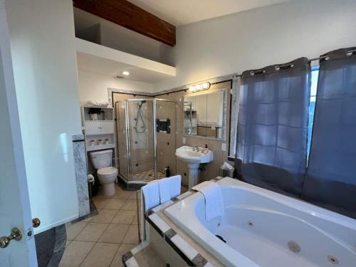 a bathroom with a tub and a toilet and a sink at Casa de Abuelos, 2bd guest house, Jacuzzi, Biola, Disney, Knotts, LAX in Whittier