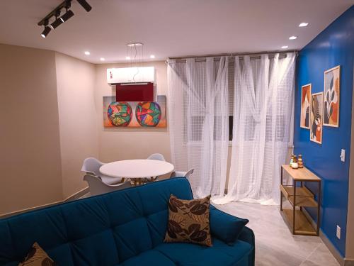a living room with a blue couch and a table at PIRAGIBE FROTA AGUIAR in Rio de Janeiro