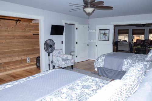 a bedroom with two beds and a fan and a chair at The Retreat by On Cue Properties 