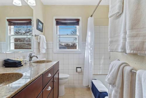 a white bathroom with two sinks and a toilet at Walk to Parks Pet Friendly Top Neighborhood in Rapid City