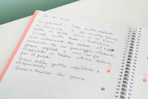 a notebook with handwriting on the pages at La Verde Rosa - Casa vacanze a due passi dal lago in Marta