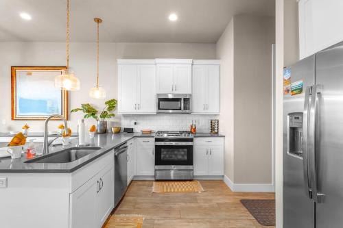 a kitchen with white cabinets and a stainless steel refrigerator at Ocotillo Springs 67 Low Prices, Private Hot Tub, Pool, Basketball Arcade, Ping Pong and Community Pool in Santa Clara