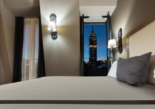 a bedroom with a bed with a view of a skyscraper at Historico Central Hotel in Mexico City