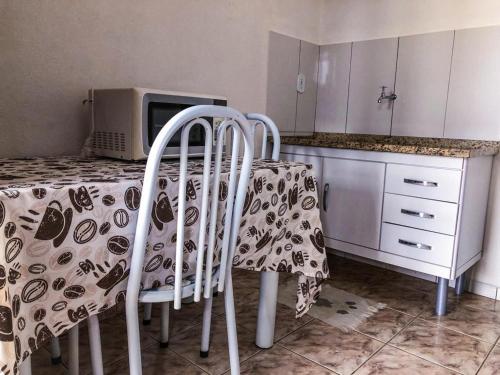 a kitchen with a table and two chairs and a microwave at Hospê Da Lita in Cunha