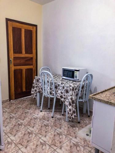 a kitchen with a table with chairs and a microwave at Hospê Da Lita in Cunha