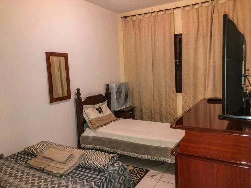 a small bedroom with two beds and a television at Hospê Da Lita in Cunha
